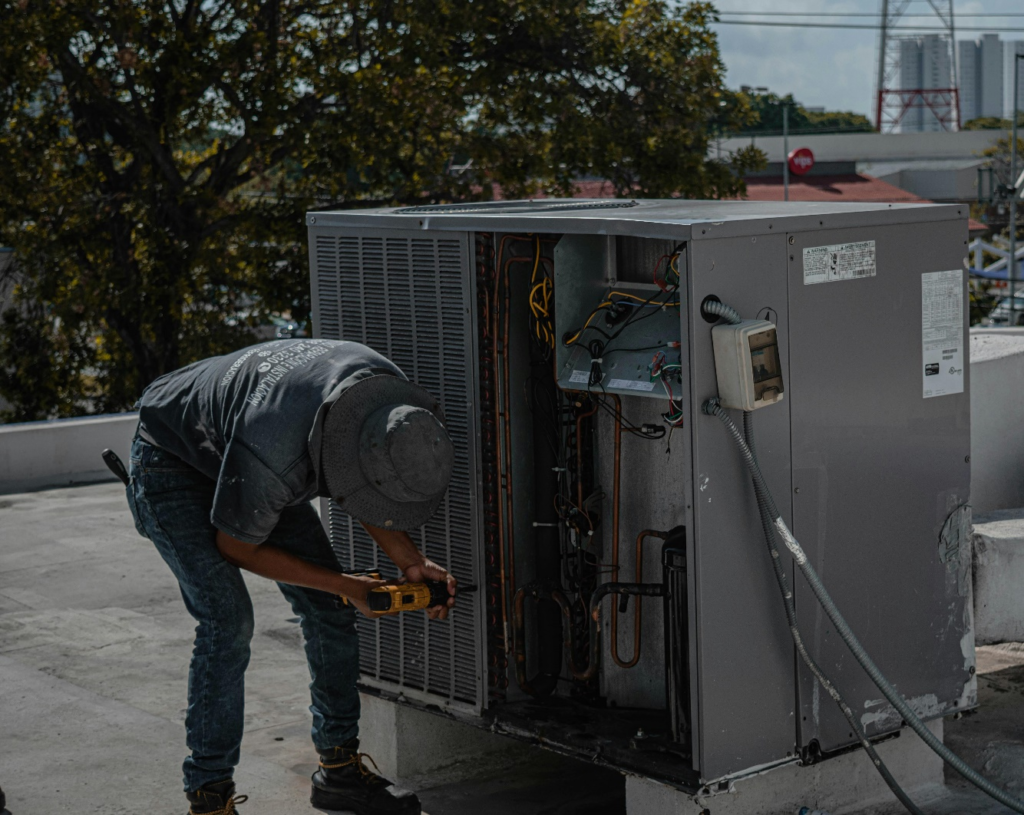 HVAC technician working on an outdoor air conditioning unit