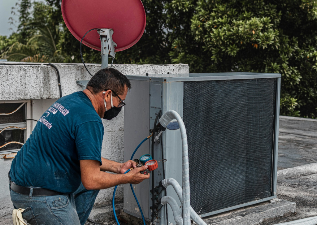 HVAC technician working on an outdoor air conditioning unit